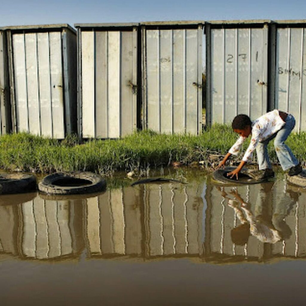 child playing in the water on old tyres